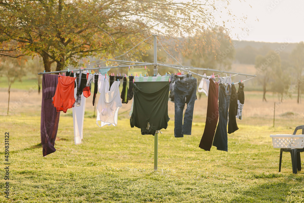 Australian backyard featuring hills hoist clothes line full of clean  washing Stock Photo