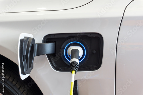 Power supply connect to electric car for add charge to the battery. Charging re technology industry transport which are the future of the Automobile. 