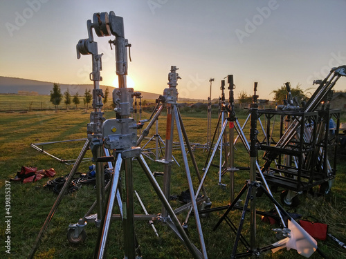 Lamp stands, tripods unloaded by film crew for filming, movie shooting in the dawn field in Hungary.