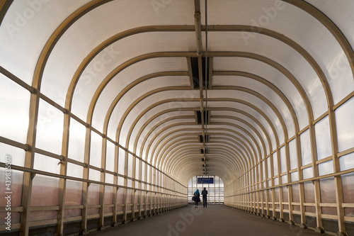 Traveling couple in symmetrical passenger tunnel to the airport terminal  color photo. 