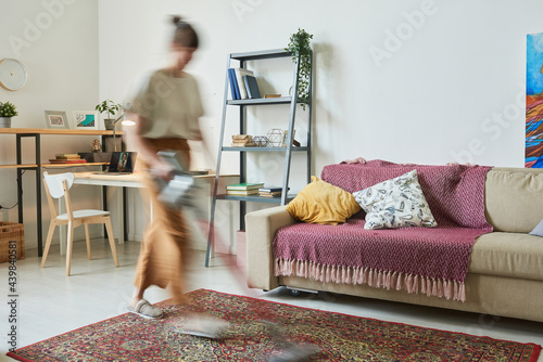 Foto Blurred motion of housewife doing housework in the room at home