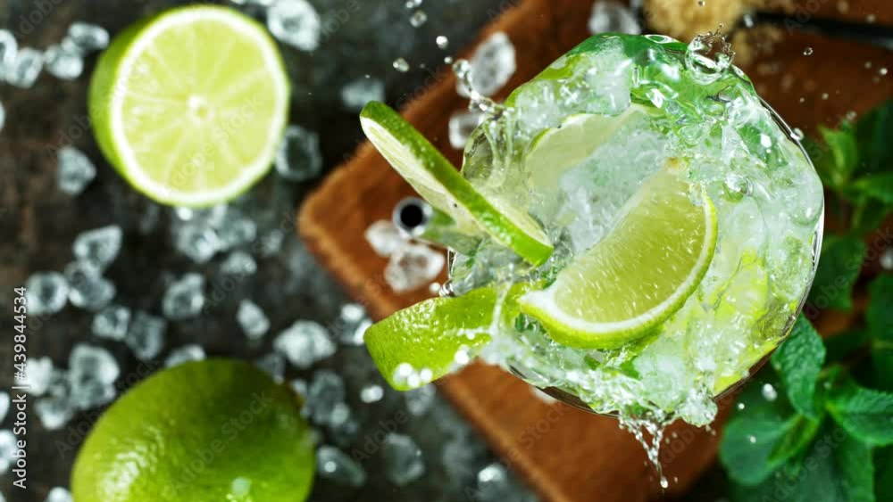 Refreshing mojito cocktail in a glass on black stone table, macro super slow motion filmed on high speed cinematic camera.