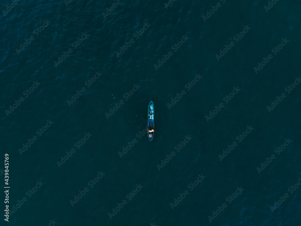 a fishing boat in the middle of blue water 