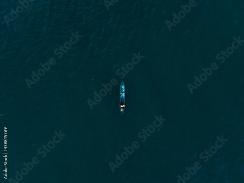 a fishing boat in the middle of blue water 