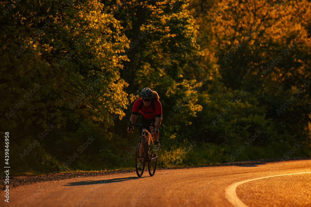Fototapeta premium Bicycle rider pedaling on a country road