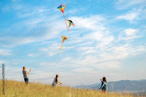 Принти на полотні Children kite fighting with flying colorful kites - popular outdoor toy on the high grass mountain meadow