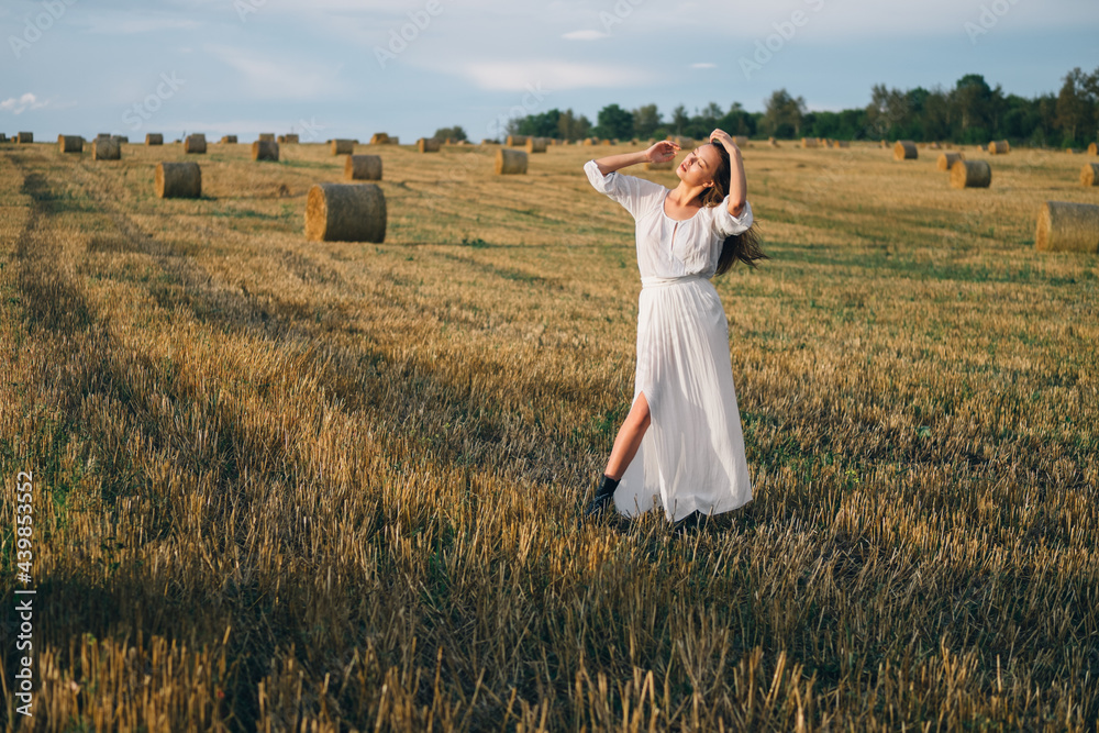 beautiful woman in a white dress walks across the field. beautiful woman in a white dress walks across the field.