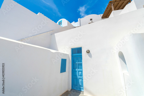 Greece Santorini island wide angle view of colorful gates with wooden doors by whitewased houses in oia  at summer during daylight photo