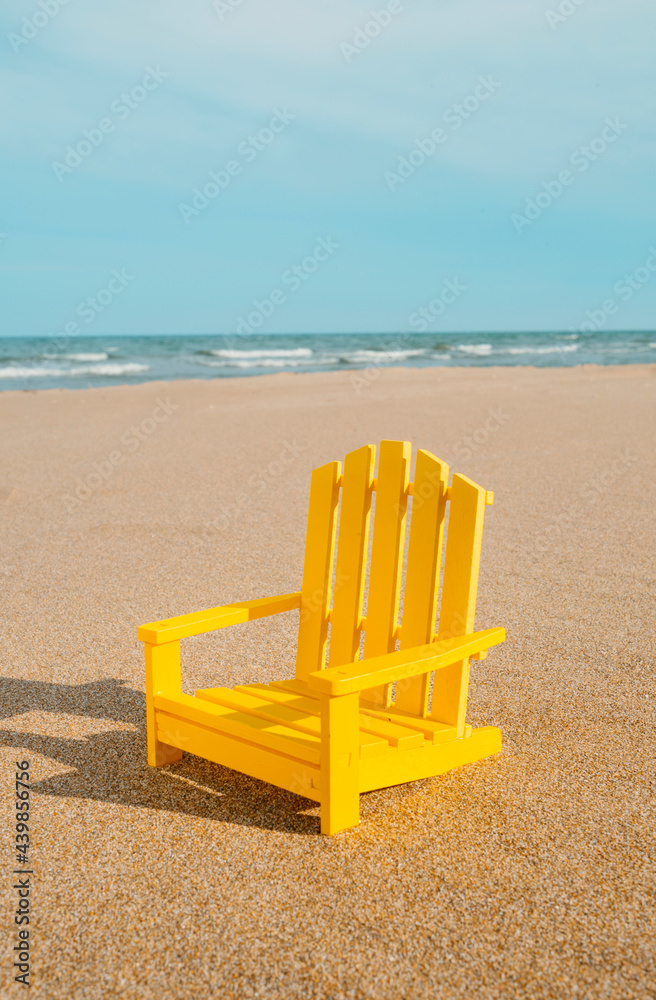 yellow miniature chair on the beach yellow miniature chair on the beach