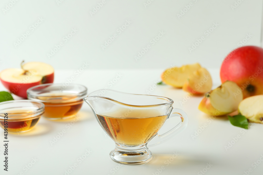 Homemade apple vinegar and ingredients on white table Homemade apple vinegar and ingredients on white table