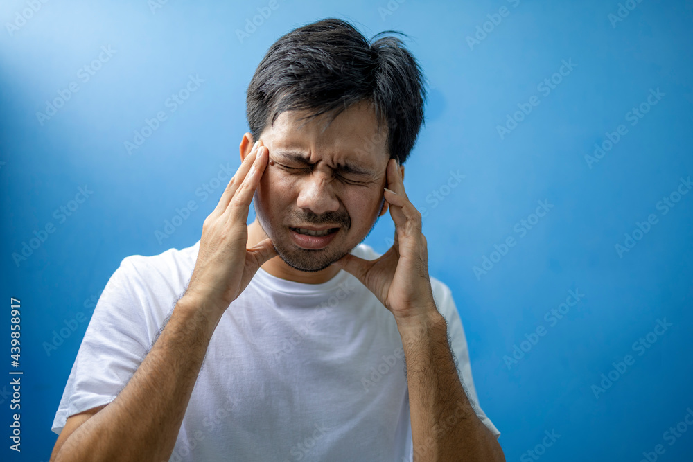 Young asian man suffering from headache and migraine, Feeling stressed. Young asian man suffering from headache and migraine, Feeling stressed.
