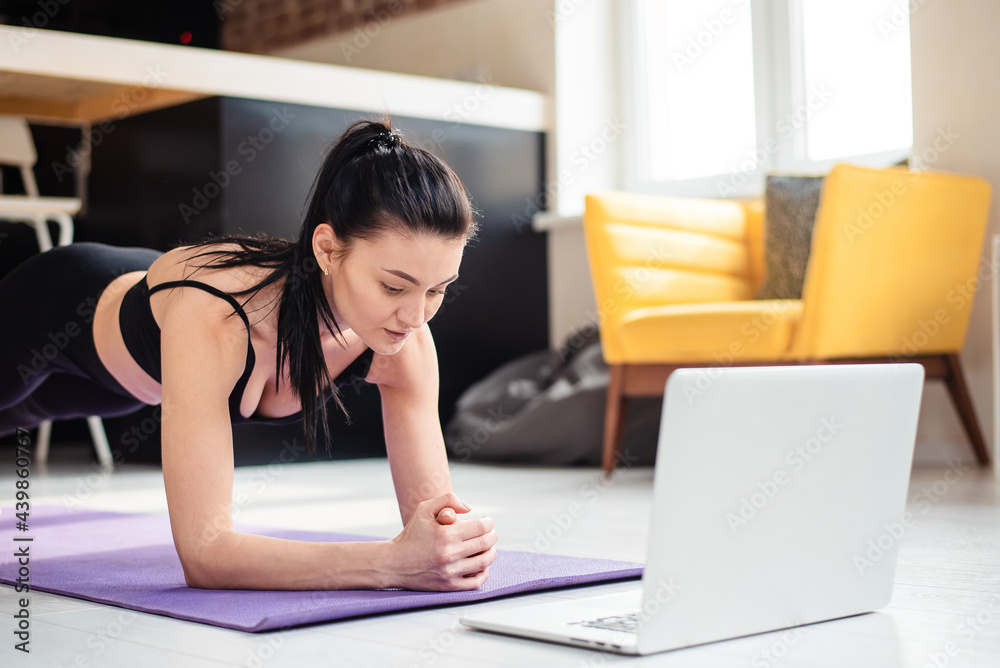 Obraz premium Concentrated woman using laptop for training at home