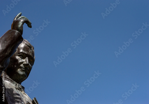 фотографія Old Bronze statue of a Saint with an hand up to the blue sky
