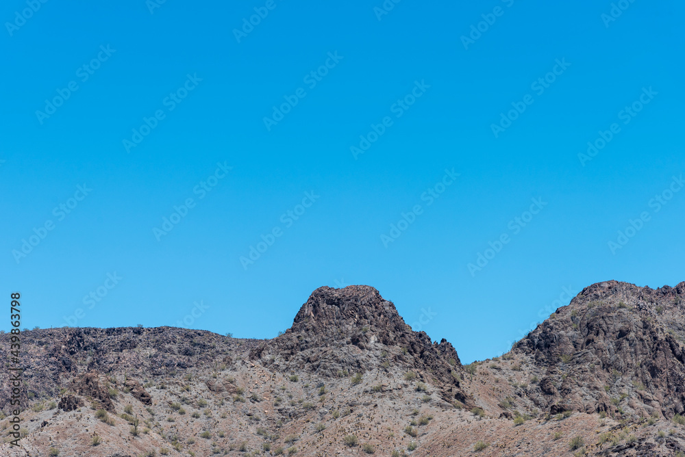 Barren rocky desert mountain under a blue sky