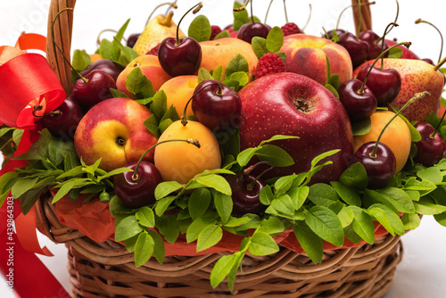 Basket with fresh fruits and berries on a white background