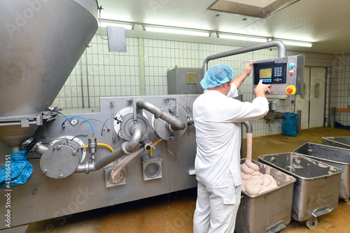 Herstellung von Wurst in einer Fleischerei - industrielle Lebensmittelproduktion in einer Fabrik am Fliessband // 
