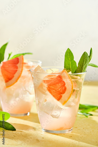 Pink cocktail with ice and sage, selective focus.