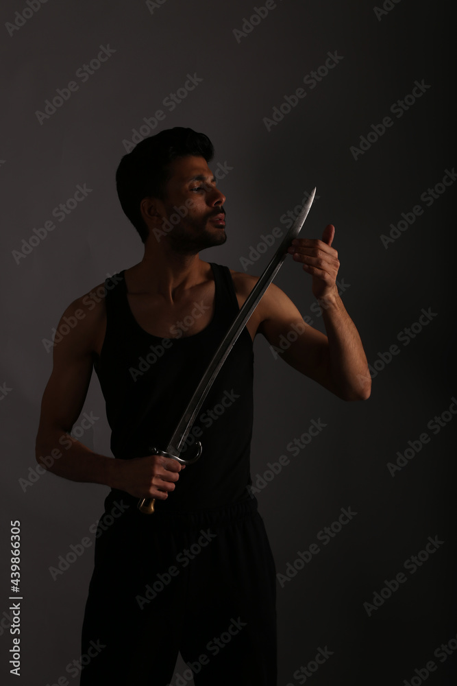 Fototapeta premium A man with long knife in shadows