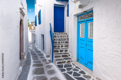 Traditional greek house with blue door and staircase in narrow city alley. Mykonos Island, Greece. © Nancy Pauwels