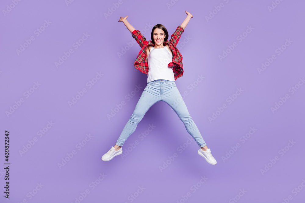 Full size photo of cool brunette hairdo young lady jump wear red shirt jeans isolated on purple color background