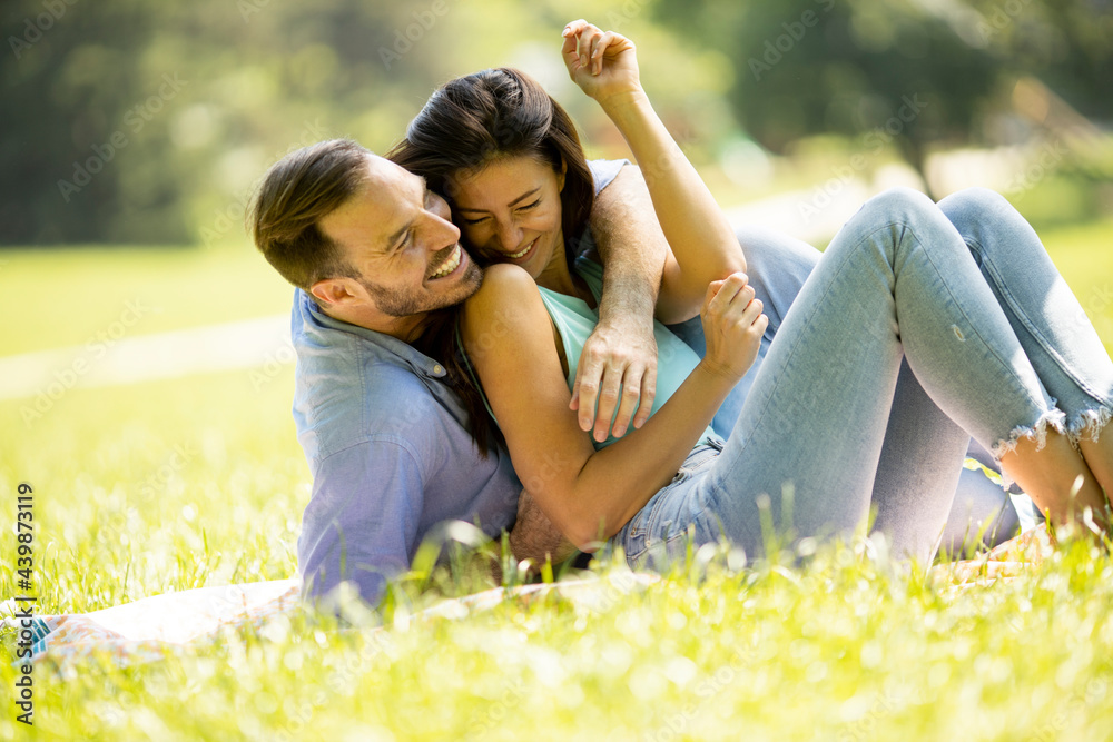 Affectionate young couple sitting on the green grass Affectionate young couple sitting on the green grass