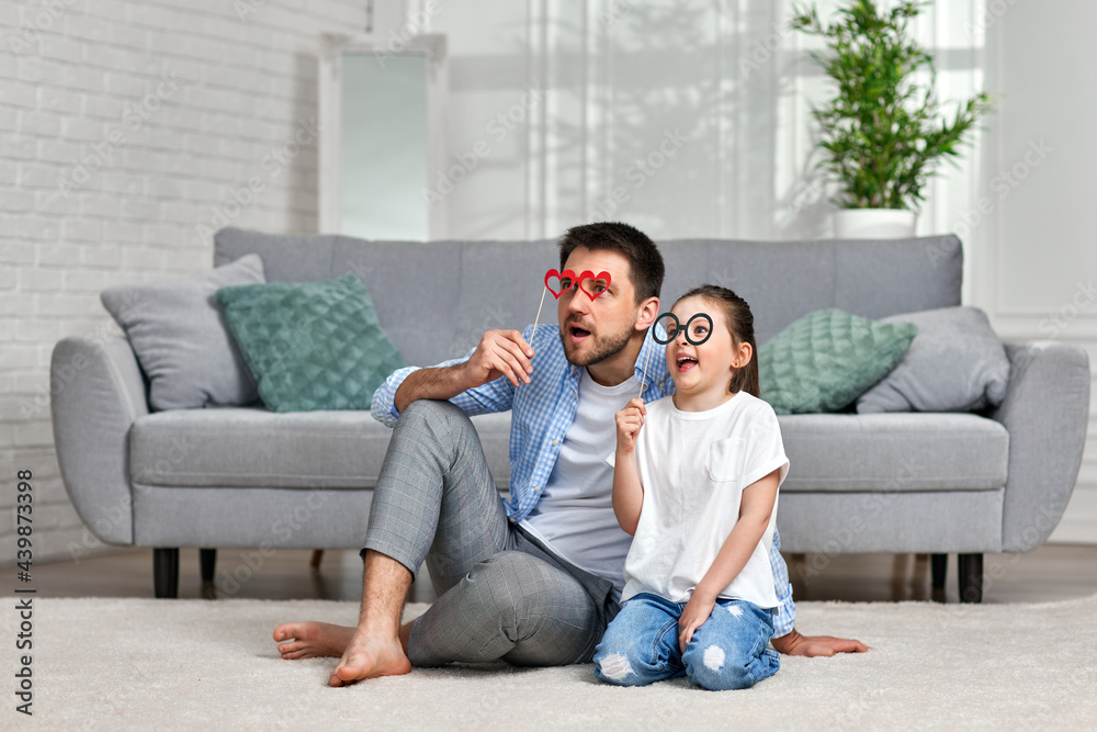 dad and little kid girl holding paper glasses