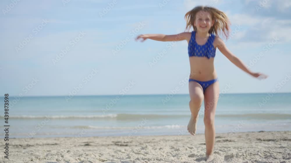 Cheerful carefree girl in a bathing suit dancing on the sandy seashore. Rest during the holidays. Great mood. Cheerful carefree girl in a bathing suit dancing on the sandy seashore. Rest during the holidays. Great mood.