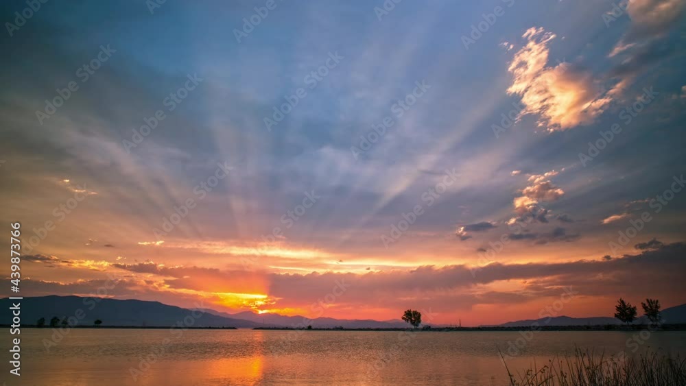Sun rays reaching into the sky during sunset timelapse over Utah Lake.