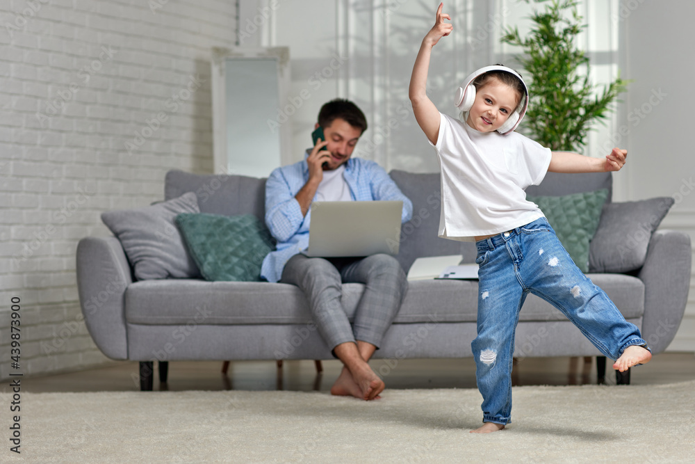 kid dancing and busy dad working with laptop at home kid dancing and busy dad working with laptop at home