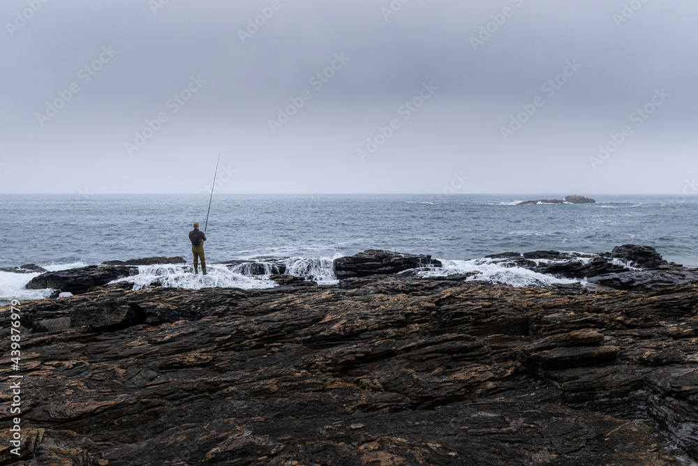 Fisherman trying to fish the dinner on the cliffs