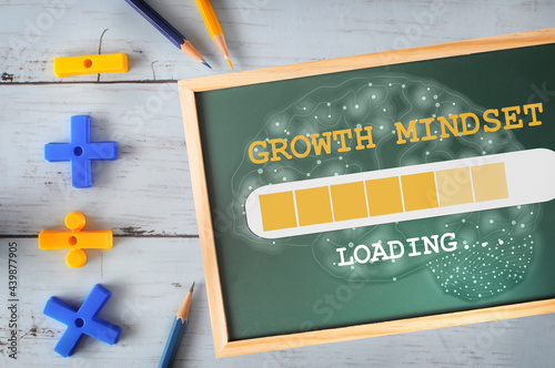 Growth mindset and brain loading on chalkboard with math symbol and colored pencil on wooden desk. Reskilling and up skilling concept and technology transformation learning model idea