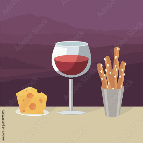 A glass of red wine with snacks against the backdrop of the tuscany hills