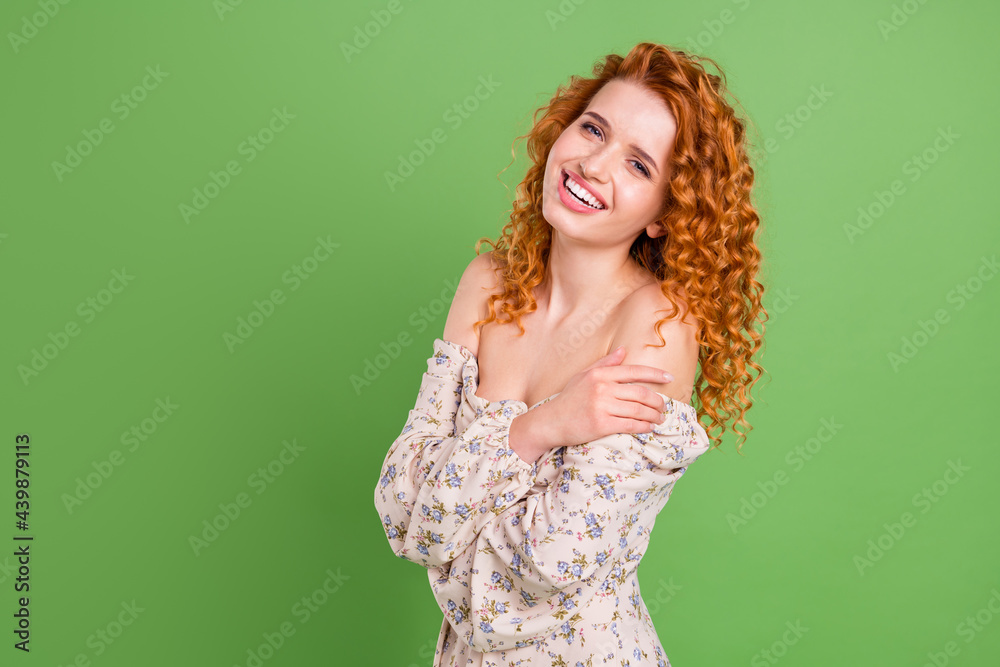 Photo of cheerful charming young woman hug herself smile positive isolated on green color background Photo of cheerful charming young woman hug herself smile positive isolated on green color background