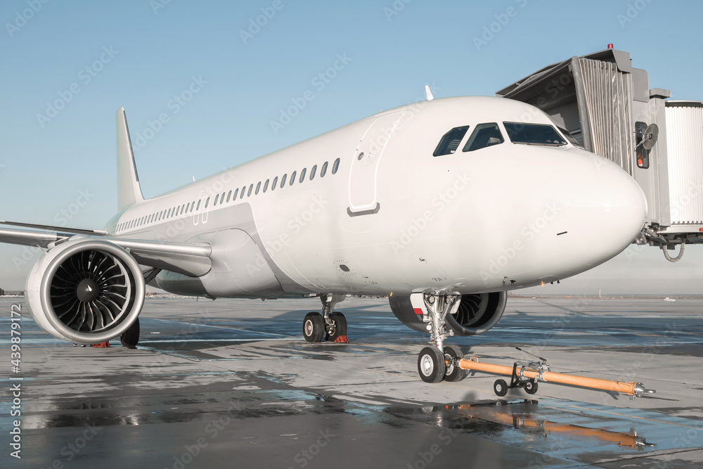 Passenger airplane with towbar at the jet bridge Passenger airplane with towbar at the jet bridge