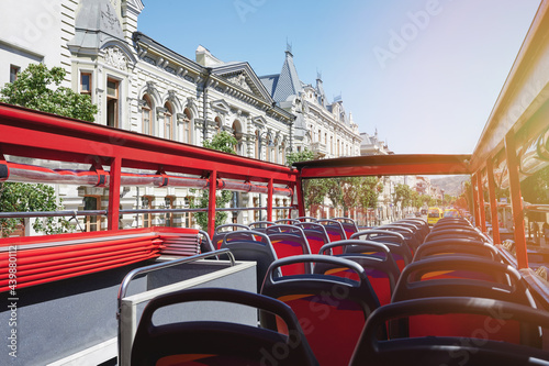 Empty red bus seats with open roof