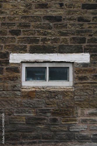 small fixed barn window in sandstone wall in a house in England