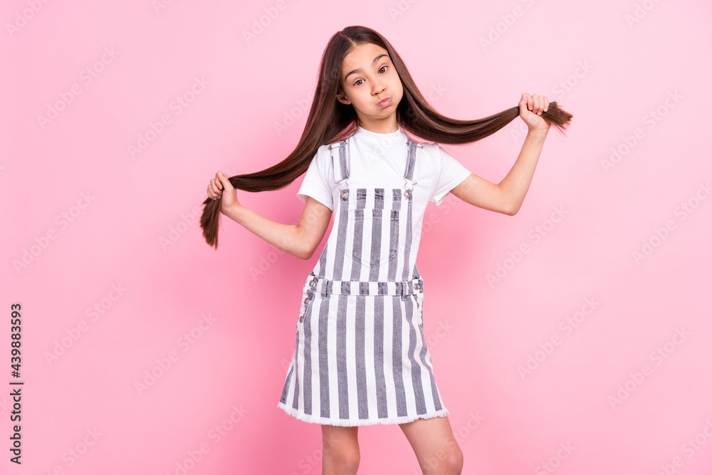 Photo portrait of small schoolgirl in overall keeping air in cheeks childish isolated pastel pink color background Photo portrait of small schoolgirl in overall keeping air in cheeks childish isolated pastel pink color background
