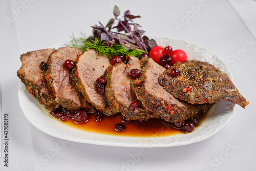Grilled sliced Beef Steak with tomatoes and rosemary on a plate Isolated on white background top view
