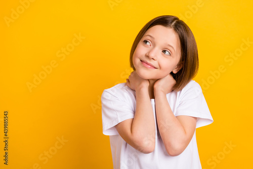Photo portrait small schoolgirl smiling cheerful cute looking empty space isolated bright yellow color background