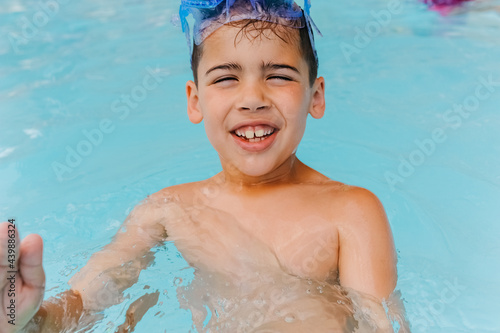 Boy laughing while trying to splash water. 