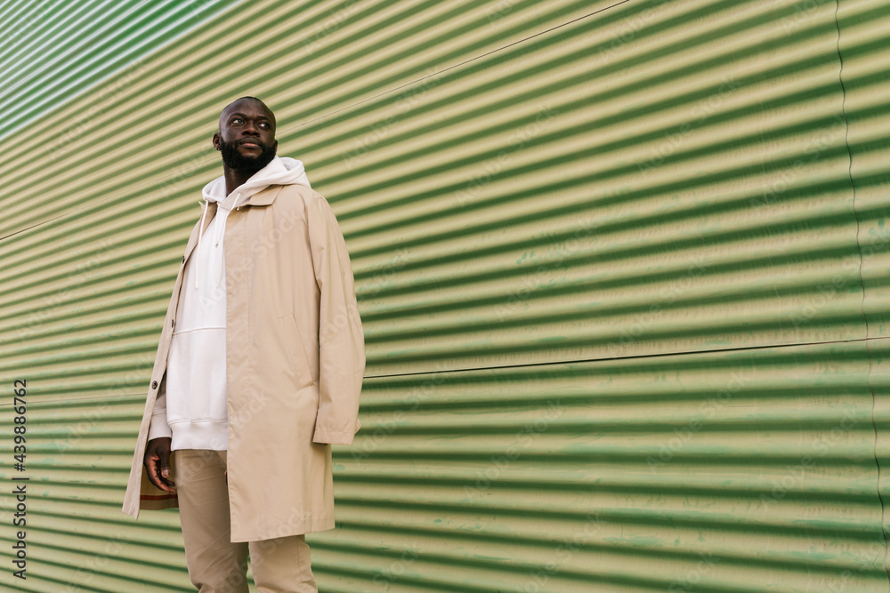 Black man in a trench coat standing outdoors Stock Photo | Adobe Stock