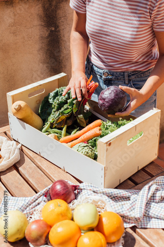 Fresh fruits and vegetables in reusable bags on kitchen table photo