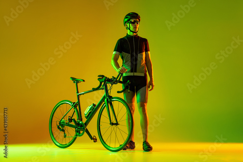 Fototapeta Naklejka Na Ścianę i Meble -  Cyclist riding a bicycle isolated against neon background