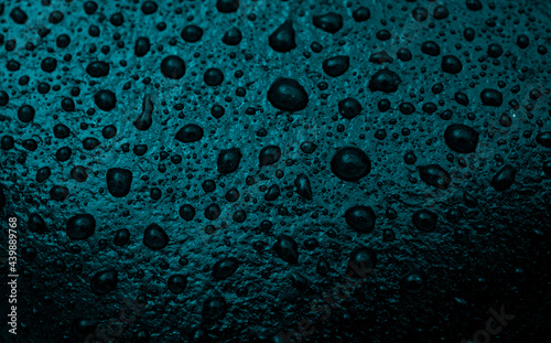 Closeup of water drops on blue stone background