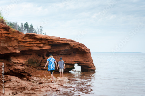 Brother and Sister Exploring Rocky Sea Cliff on PEI Beach photo