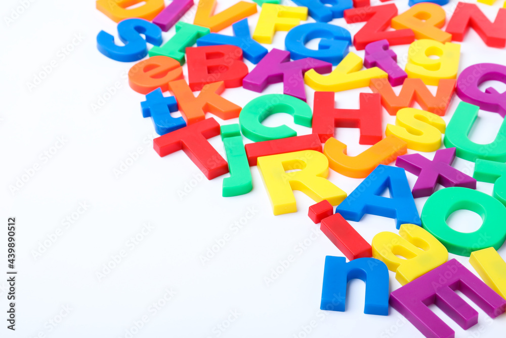 Obraz premium Many colorful magnetic letters on white background