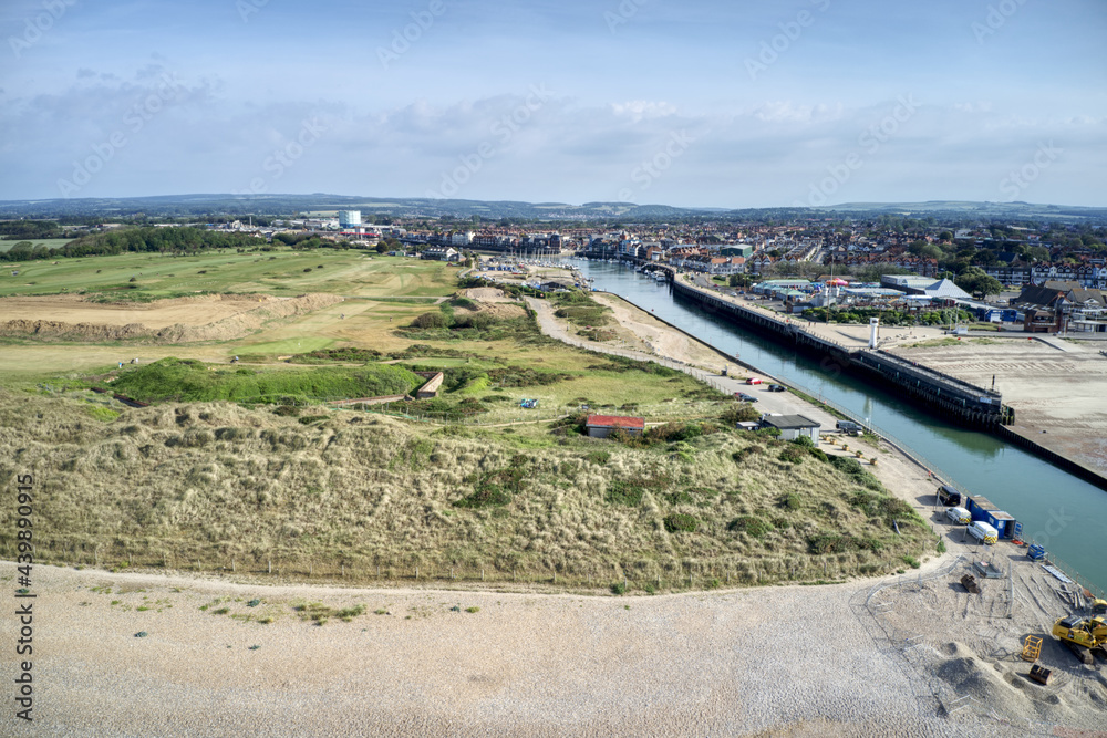 The dunes on West Beach protecting the golf course and revealing the River Arun running past the town of Littlehampton. Aerial view.
