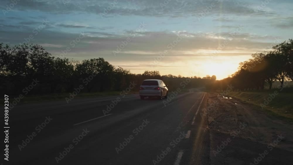 Video of a car going on a trip during a summer sunset on a long road Video of a car going on a trip during a summer sunset on a long road