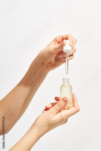 Woman with bottle of face serum