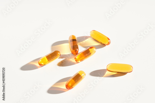 Yellow oil supplements capsules on table photo